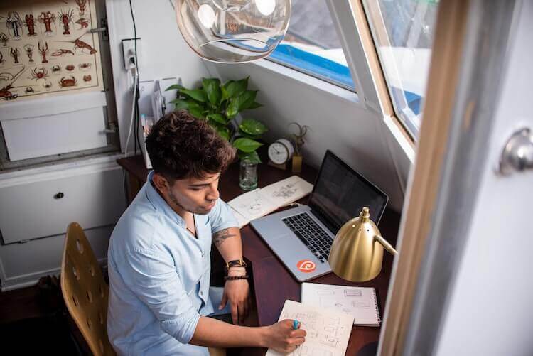 Amazon side hustle: man at desk, working (Photo by Manny Pantoja on Unsplash)