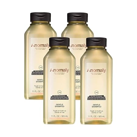 An image of four bottles of Anomaly brand shampoo. The bottles are a golden color with black lids. The label reads "Anomaly Gentle Shampoo".