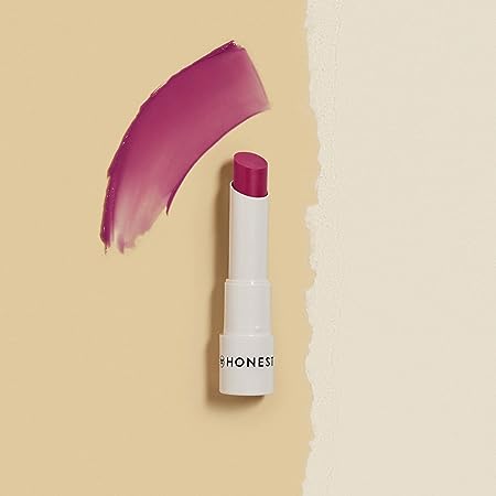 An image of Honest brand lipstick. The lipstick is dark pink and is in a cream-colored tube. The lipstick is open to show the color.