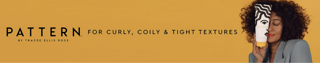 A banner image for the beauty brand Pattern. The image has a dark golden yellow background, with an image of Tracee Ellis Ross holding up a bottle of Pattern shampoo. The image has black text that reads "Pattern by Tracee Ellis Ross. For curly, coily & tight textures."